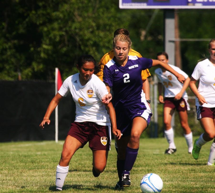 Junior Sophie Keller fights a Cougar for possession of the ball