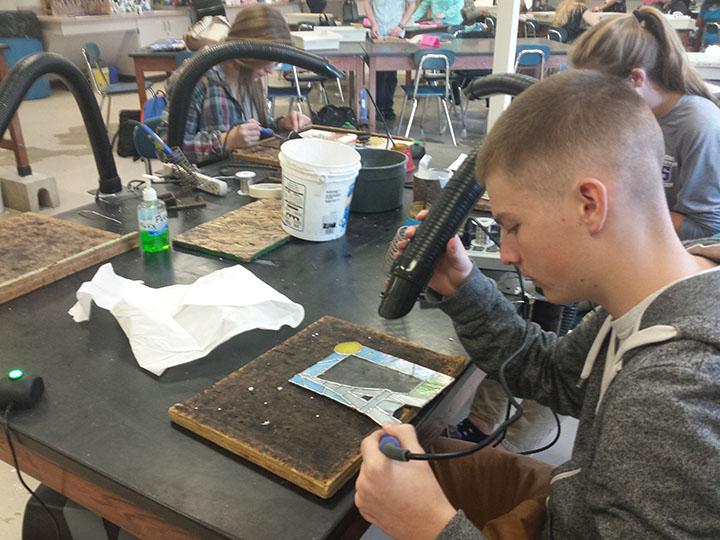 Stain glass students work on picture frames