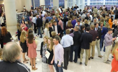Parents and new NHS members gather in the atrium to take photos.
