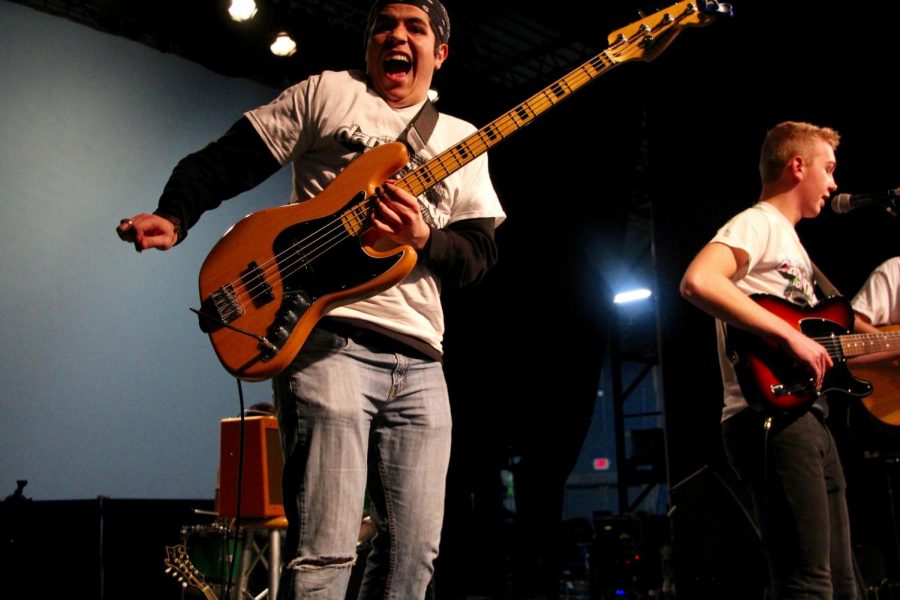 South senior and Elm Heights Band member Daniel Deckard jumps up while playing his bass guitar. 