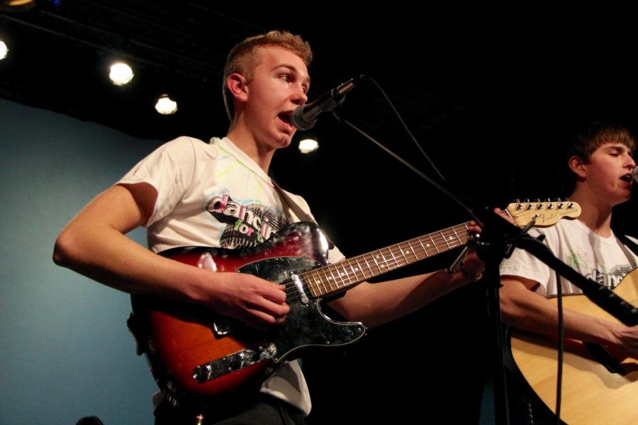 South graduate and Elm Heights Band member Hank Ruff sings and play guitar during the band's performance.