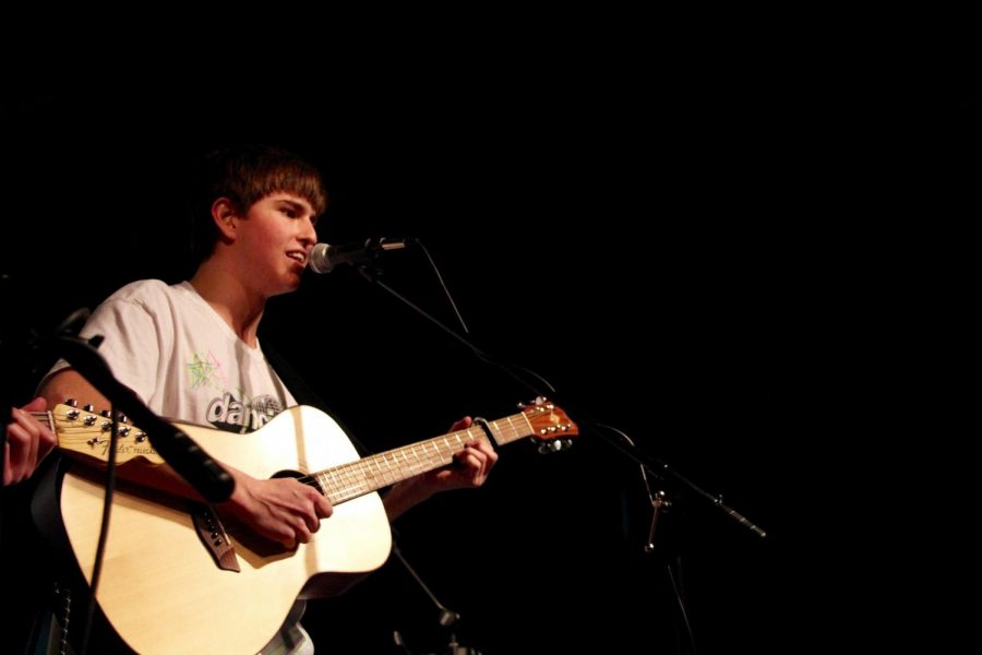 South graduate and Elm Heights Band member Will Riggert plays guitar and sings while performing during Red Hot for Riley.