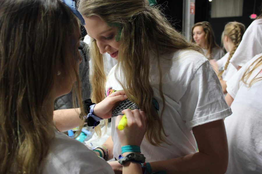 South junior Zoe Verteramo helps color South junior Riley Eurtons shirt.