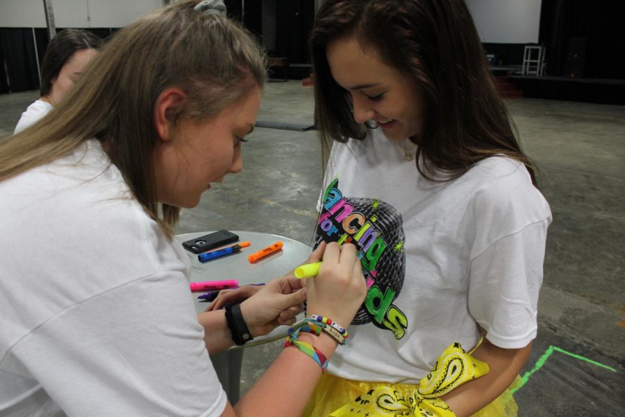 South junior Emily Doehla helps color South junior Savannah Trimble's shirt