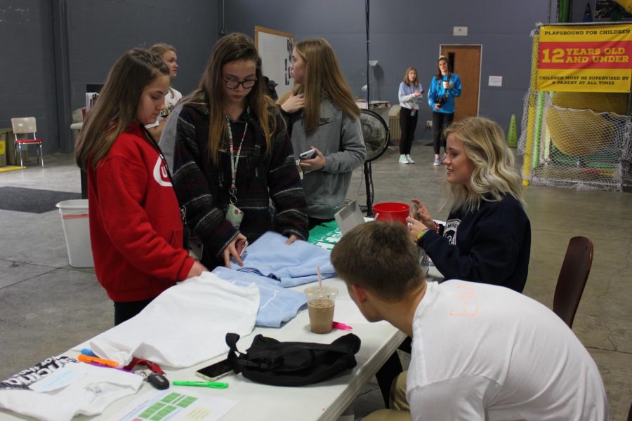 Middle school students check out the merchandise table.