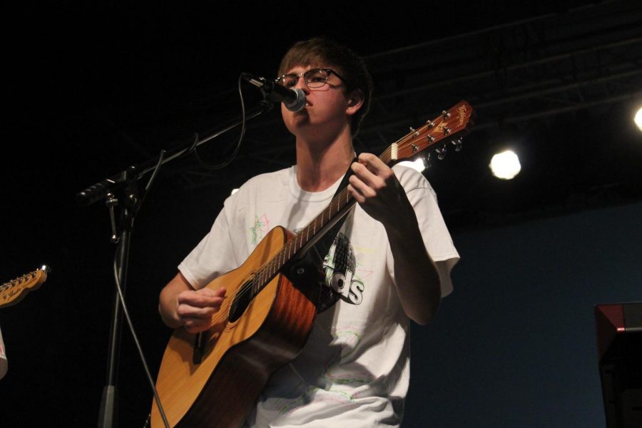 South graduate and Elm Heights Band member Will Riggert sings into the microphone while performing.