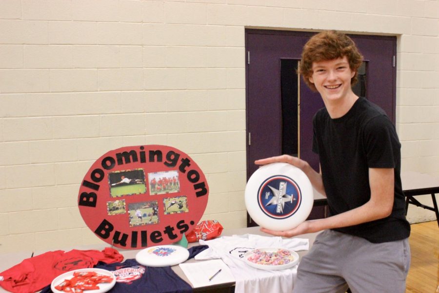 Sophomore Will Quigley poses with a frisbee in front of the Bloomington Bullets Ultimate Frisbee team booth.