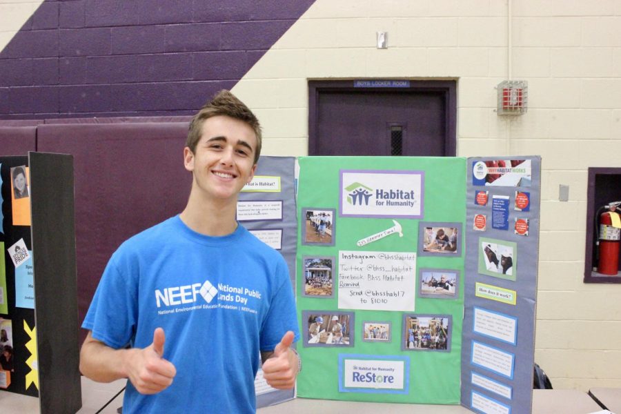 Senior Jack Foster poses in front of the Habitat for Humanity club booth.