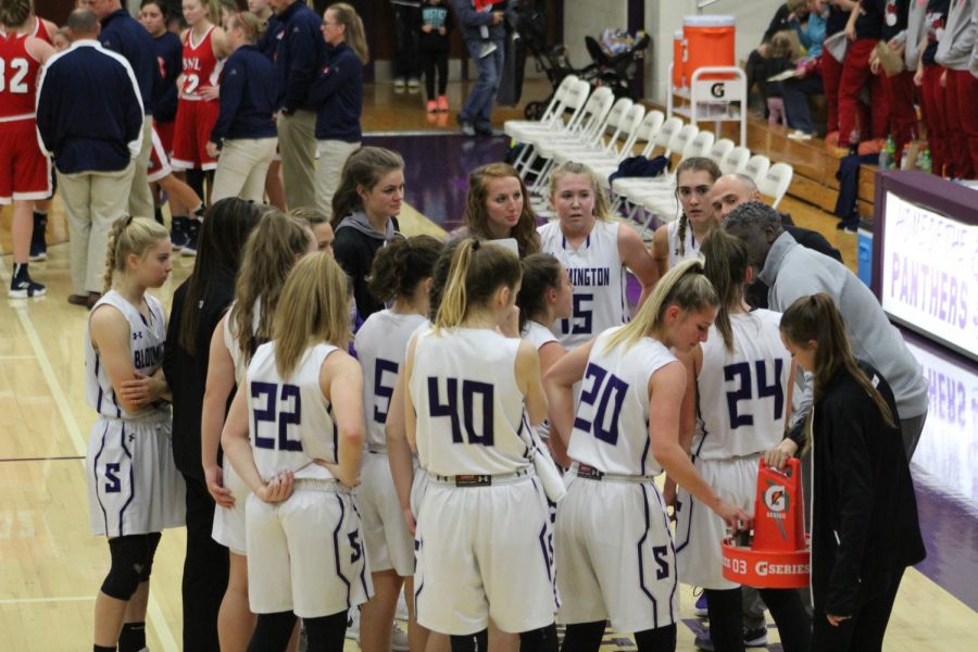 The whole team gathers during a timeout to discuss the game