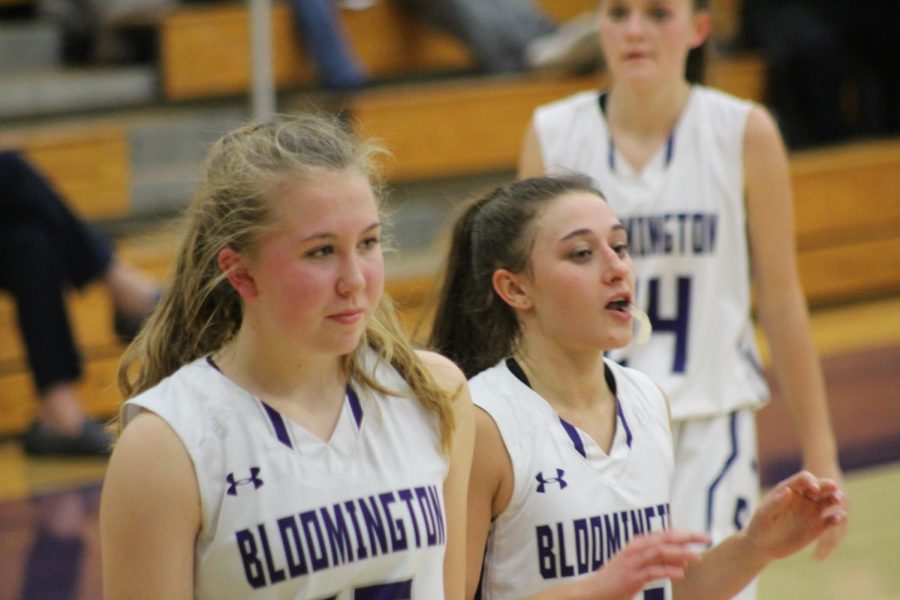 Junior Clara Voskuil (15) and senior Addy Blackwell (21) watch the team as Lauren Conner (24) walks toward them