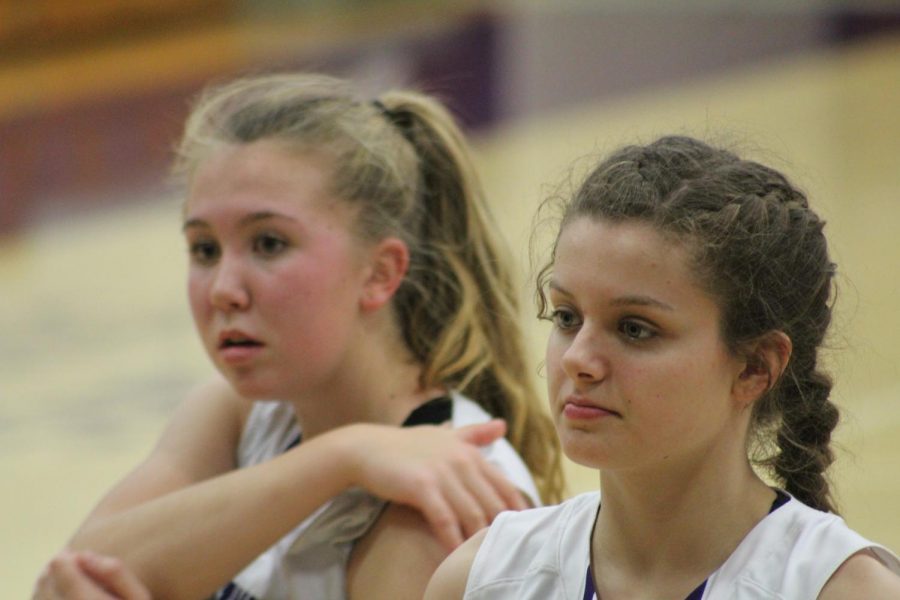 South juniors Clara Voskuil (15) and Hannah Miller (23) watch the team warm-up during half time 