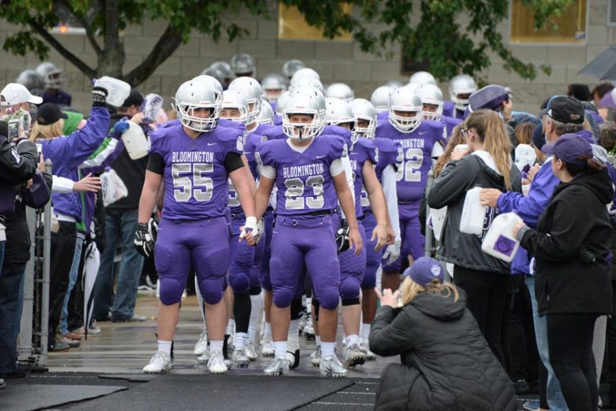 The boys football team prepares to rush on field.