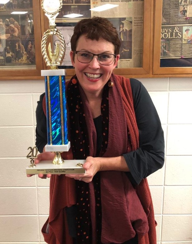 Theater director Catherine Rademacher happily shows off their trophy.