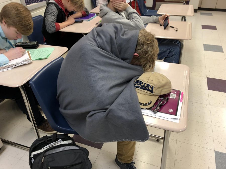 Senior Kurt Danielson wraps himself in a blanket during first period.