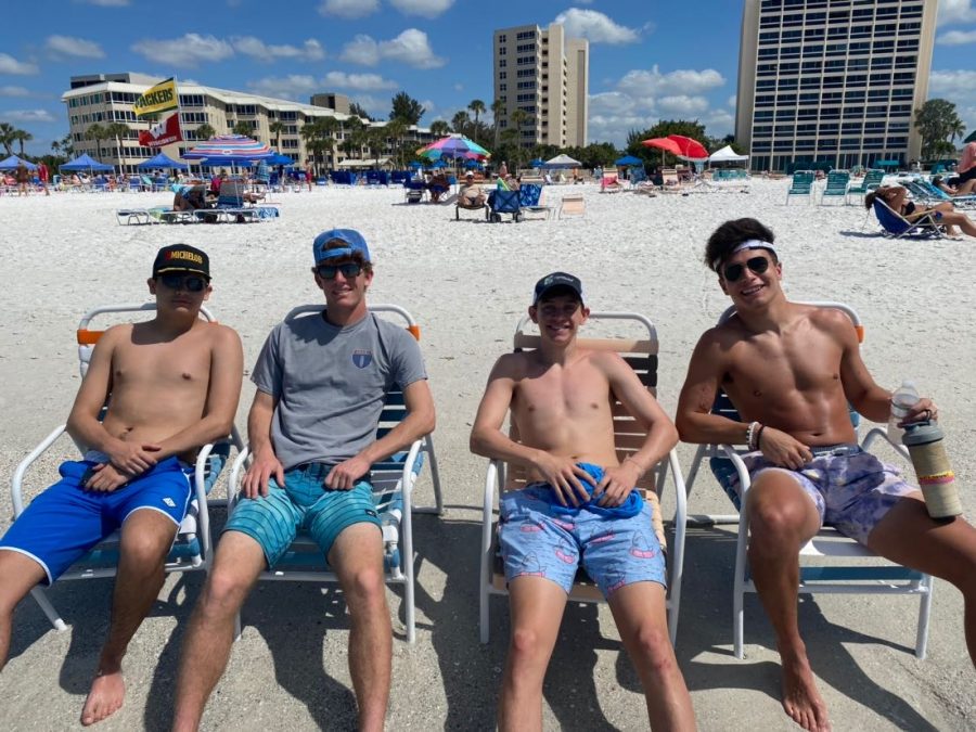 Four friends just chilling on a beach, trying to avoid COVID-19