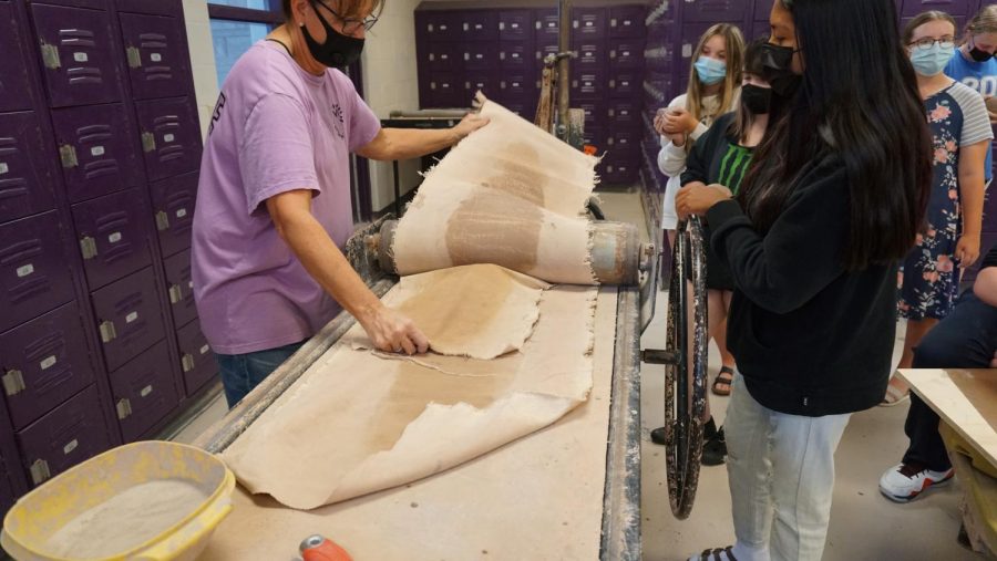 Art teacher Stephanie Benham works with students in ceramics class. 