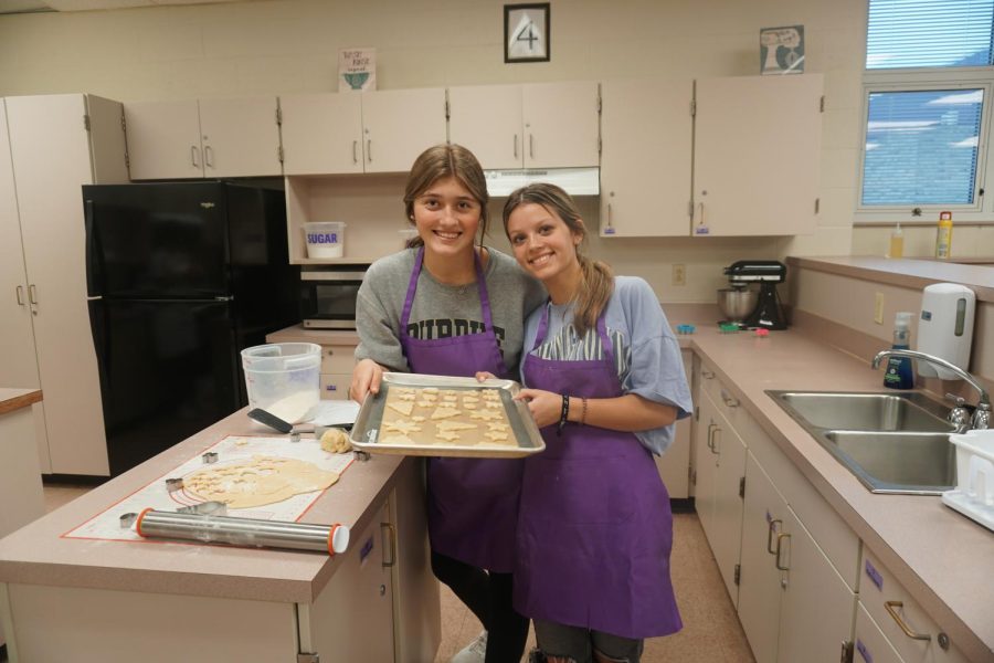 Students bake cookies in class, Presley Roll and Whitney Kelley pose with theirs