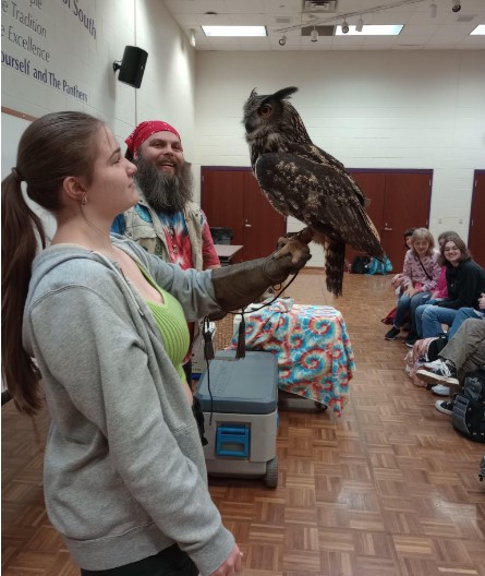 Senior Abigail Pickens holds owl at zoologys animal presentation