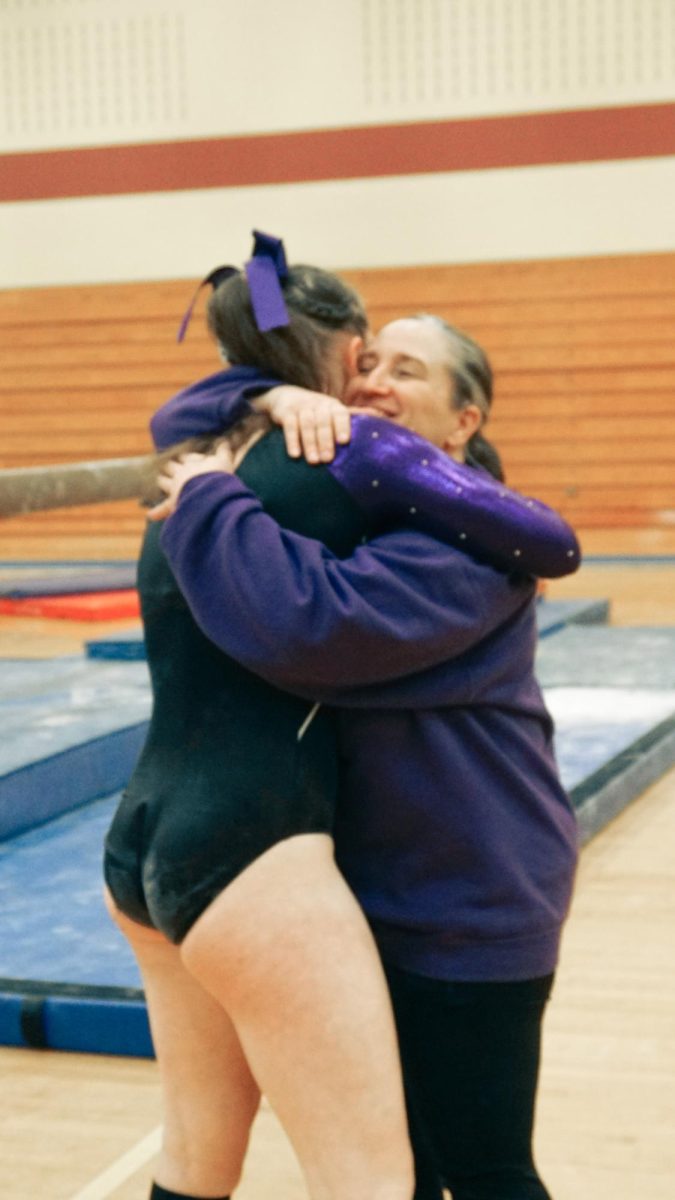 Bloomington South gymnastics Head Coach Michelle Stroud shares a moment with junior Tristan Farris