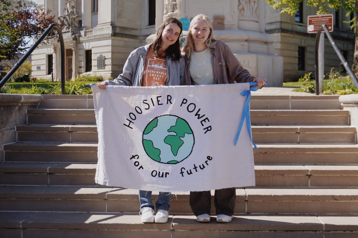 Hoosier Power Energy climate strike organizers, sophomore Alice Racek (left) and freshman Lydia Arnold (right) display a banner in support of Fridays for Futures 2024 Global Climate Strike at the Monroe County Courthouse on Sunday afternoon