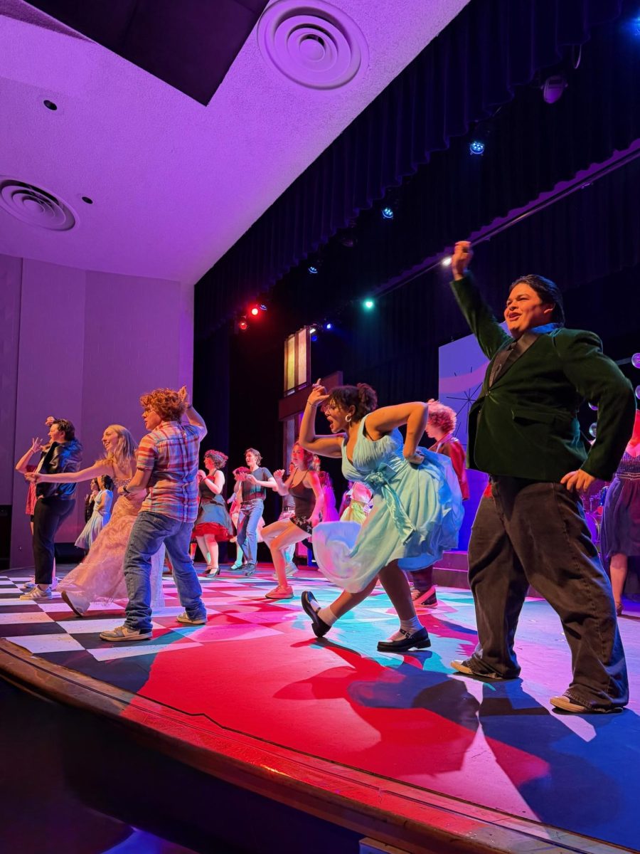 The cast of Grease rehearses "Shakin' at the High School Hop"
